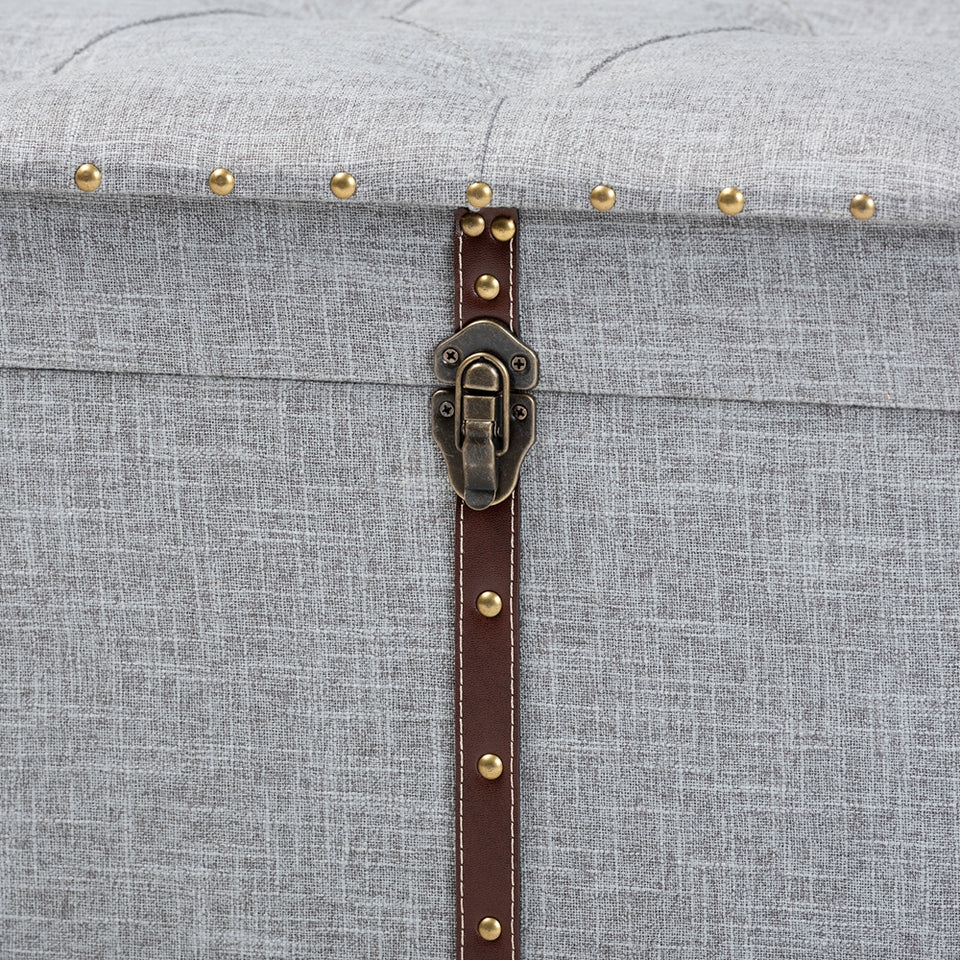 Kyra grey fabric upholstered storage trunk ottoman.